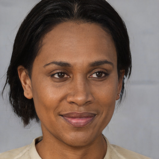 Joyful latino adult female with medium  brown hair and brown eyes