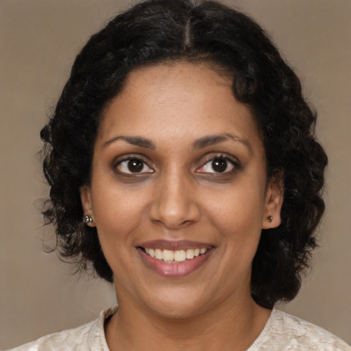 Joyful black young-adult female with medium  brown hair and brown eyes