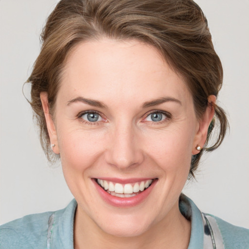 Joyful white young-adult female with medium  brown hair and blue eyes