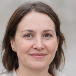 Joyful white adult female with medium  brown hair and grey eyes