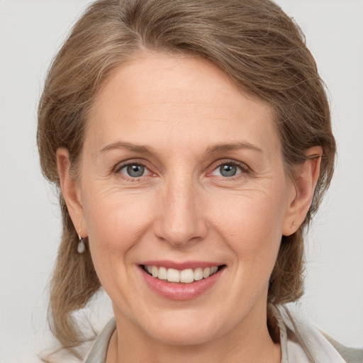 Joyful white adult female with medium  brown hair and grey eyes