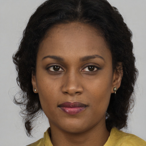 Joyful black young-adult female with long  brown hair and brown eyes