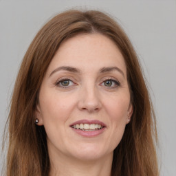 Joyful white adult female with long  brown hair and grey eyes