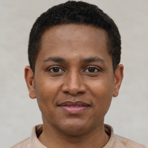 Joyful black young-adult male with short  brown hair and brown eyes