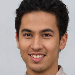 Joyful latino young-adult male with short  brown hair and brown eyes