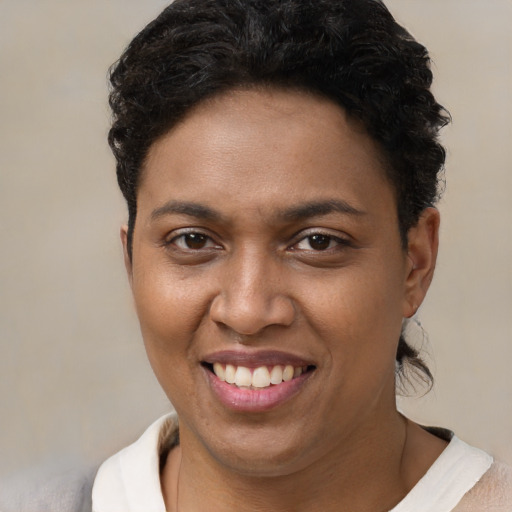 Joyful black young-adult female with short  brown hair and brown eyes