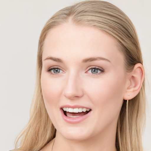 Joyful white young-adult female with long  brown hair and blue eyes