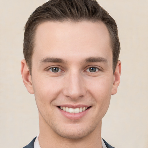 Joyful white young-adult male with short  brown hair and grey eyes