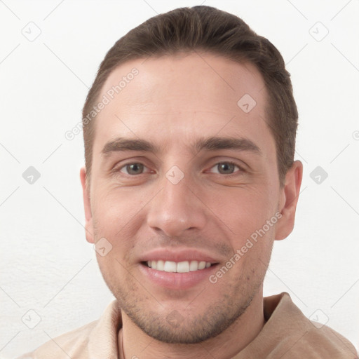 Joyful white young-adult male with short  brown hair and grey eyes