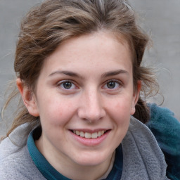 Joyful white young-adult female with medium  brown hair and blue eyes