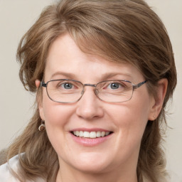 Joyful white adult female with medium  brown hair and blue eyes