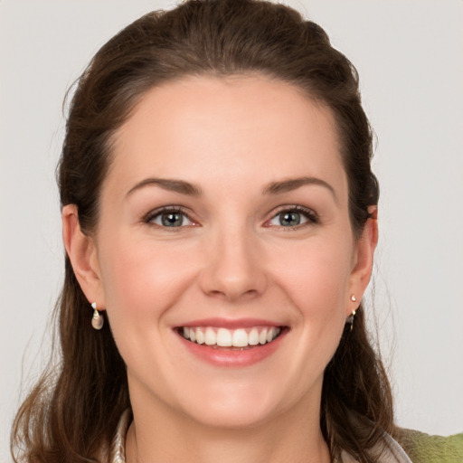 Joyful white young-adult female with long  brown hair and grey eyes