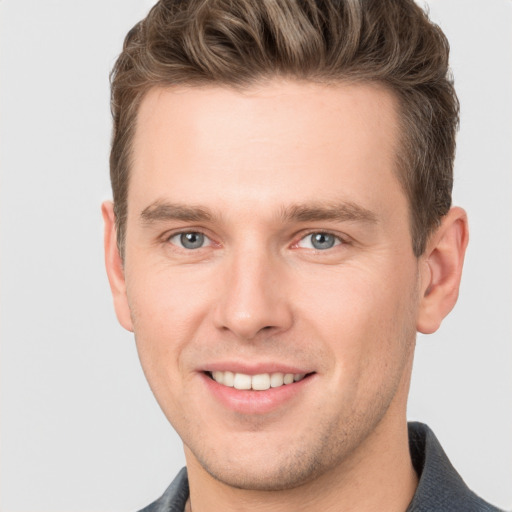 Joyful white young-adult male with short  brown hair and grey eyes