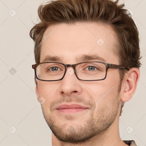 Joyful white young-adult male with short  brown hair and grey eyes