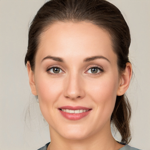 Joyful white young-adult female with medium  brown hair and grey eyes