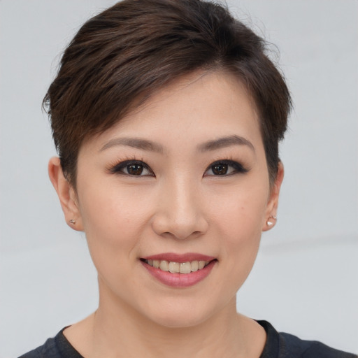 Joyful asian young-adult female with short  brown hair and brown eyes