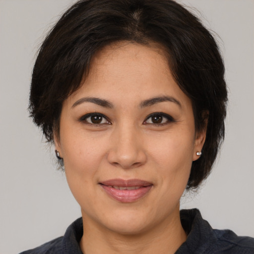 Joyful latino young-adult female with medium  brown hair and brown eyes
