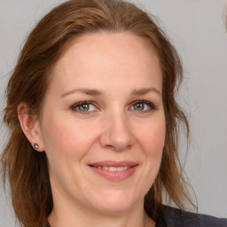 Joyful white adult female with medium  brown hair and grey eyes