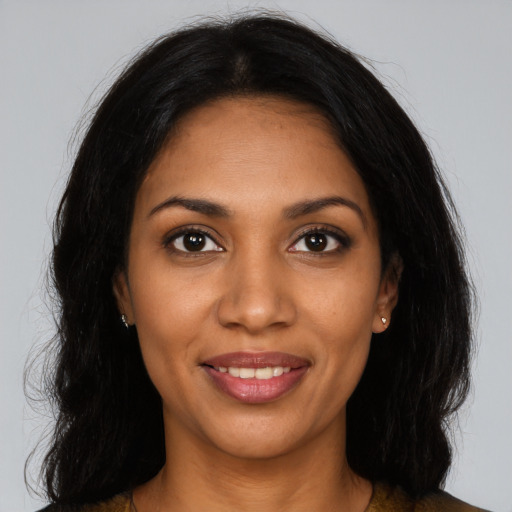 Joyful black young-adult female with long  black hair and brown eyes