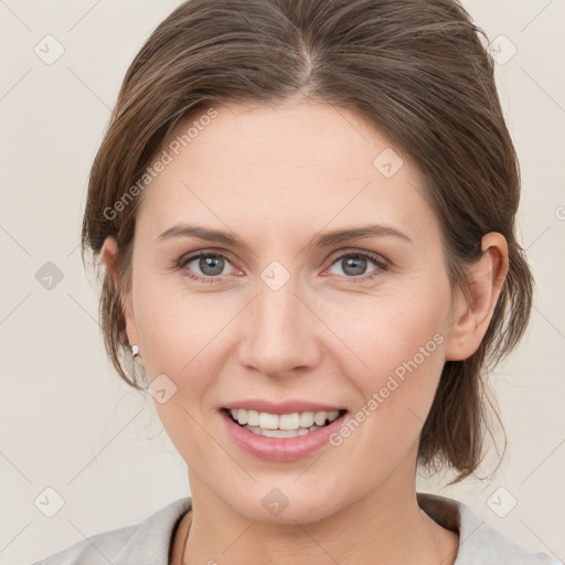 Joyful white young-adult female with medium  brown hair and grey eyes