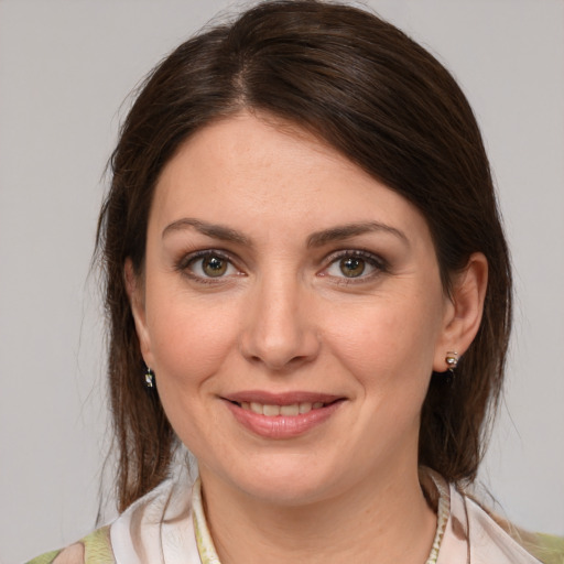 Joyful white young-adult female with medium  brown hair and green eyes