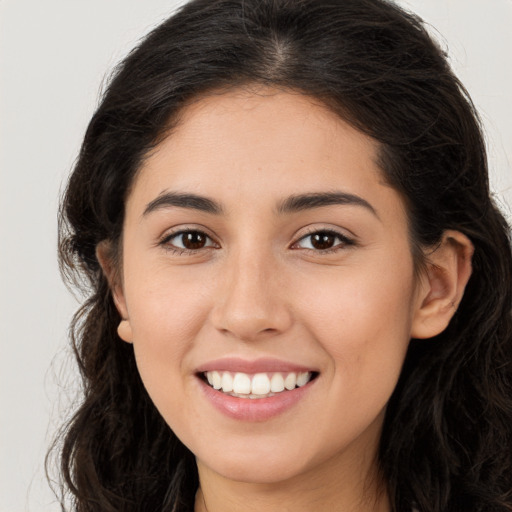 Joyful white young-adult female with long  brown hair and brown eyes