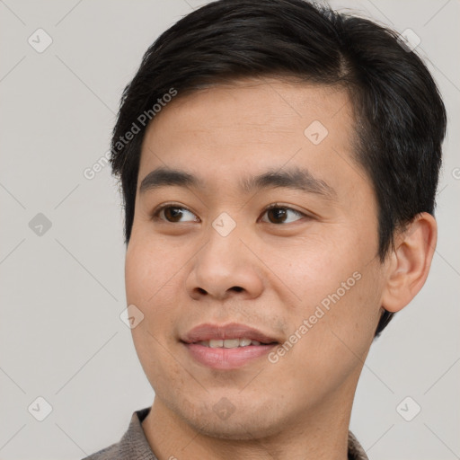 Joyful asian young-adult male with short  brown hair and brown eyes