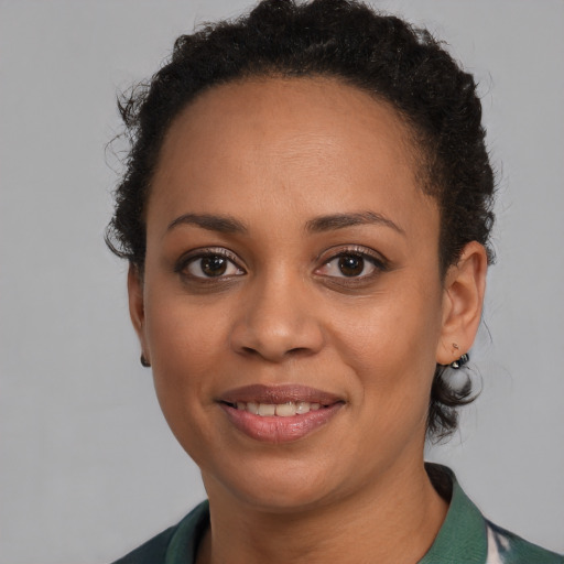 Joyful black young-adult female with short  brown hair and brown eyes