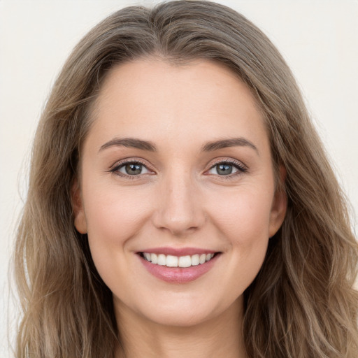 Joyful white young-adult female with long  brown hair and green eyes