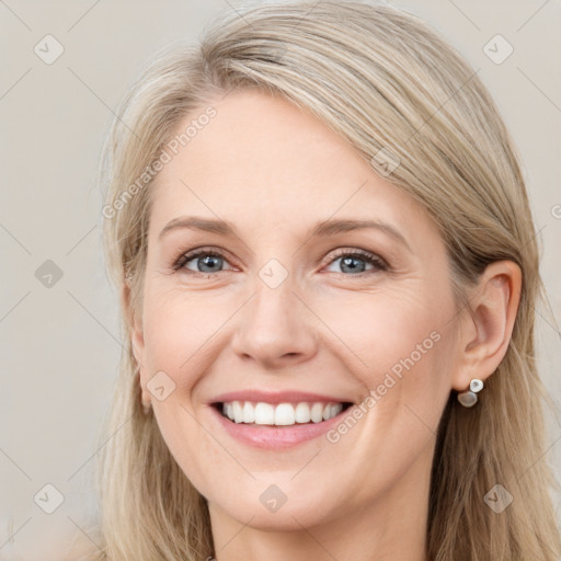 Joyful white adult female with long  brown hair and blue eyes