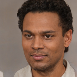 Joyful black young-adult male with short  brown hair and brown eyes