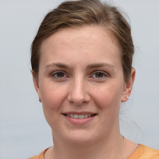 Joyful white young-adult female with short  brown hair and grey eyes