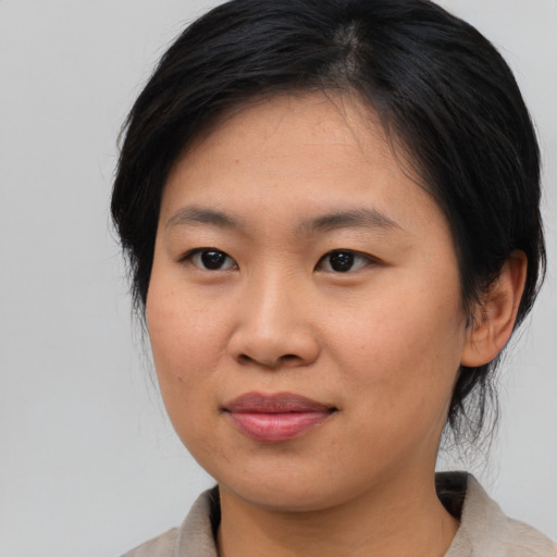 Joyful asian young-adult female with medium  black hair and brown eyes