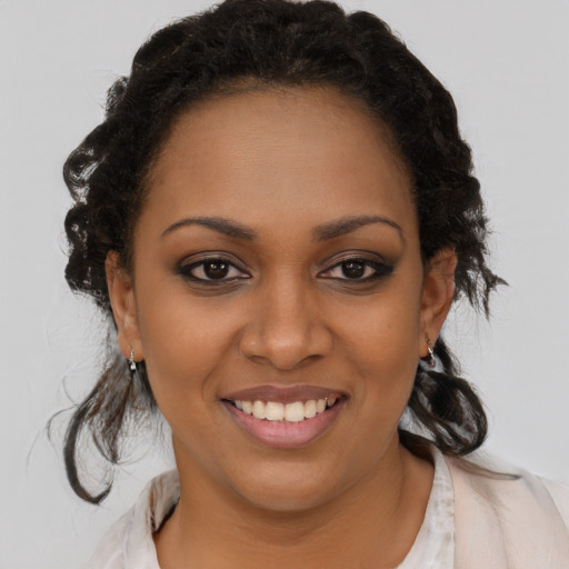 Joyful black young-adult female with medium  brown hair and brown eyes