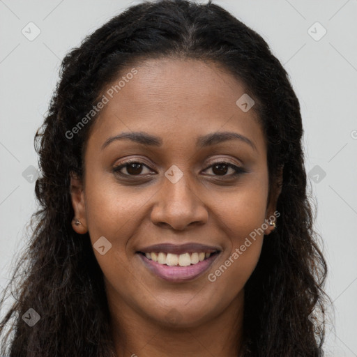 Joyful black young-adult female with long  brown hair and brown eyes