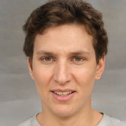 Joyful white adult male with short  brown hair and grey eyes