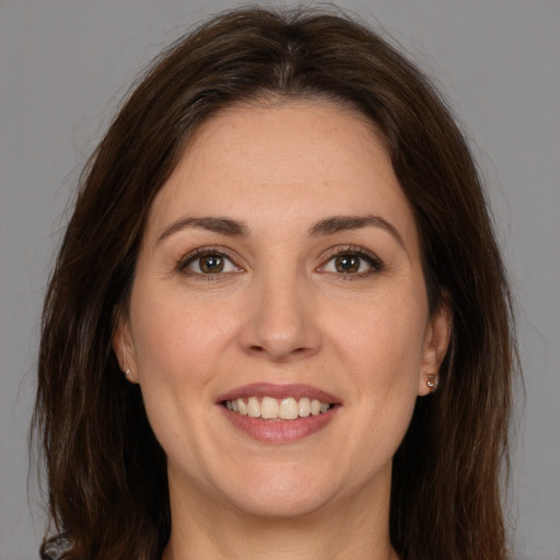 Joyful white young-adult female with long  brown hair and brown eyes