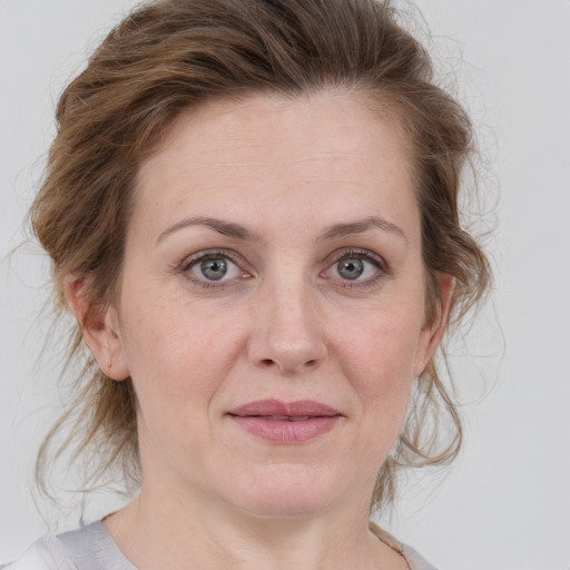 Joyful white adult female with medium  brown hair and grey eyes