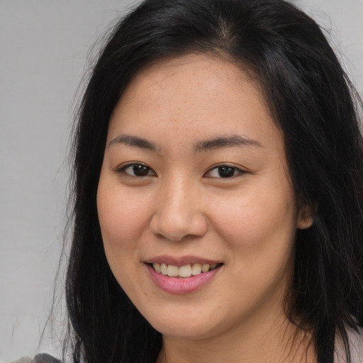 Joyful asian young-adult female with long  brown hair and brown eyes