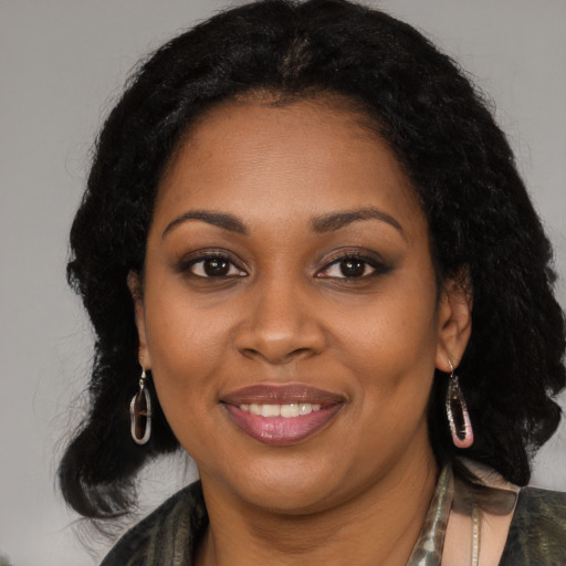 Joyful black young-adult female with long  black hair and brown eyes