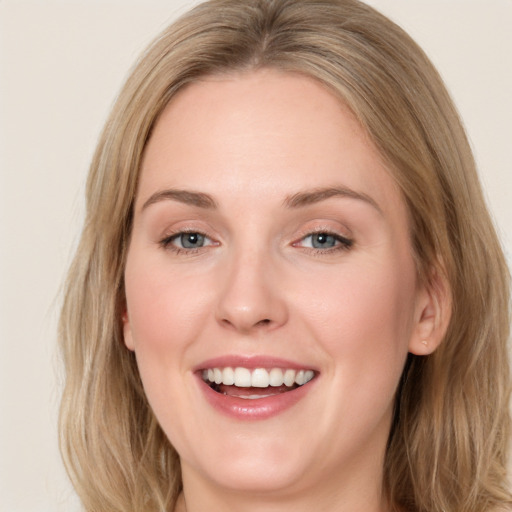 Joyful white young-adult female with long  brown hair and blue eyes