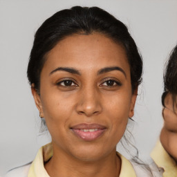 Joyful latino young-adult female with medium  brown hair and brown eyes