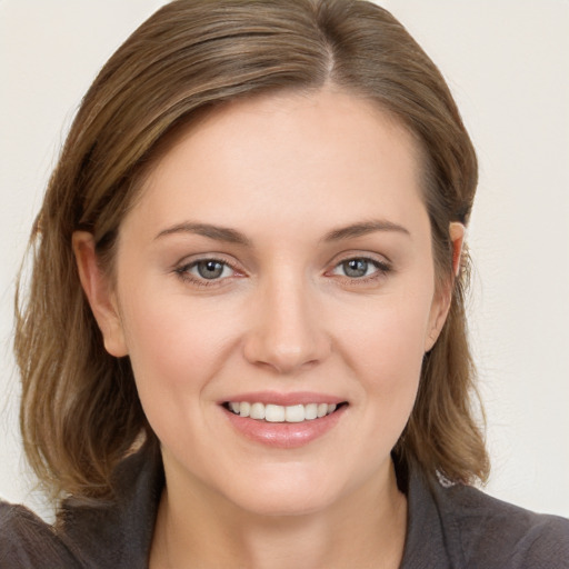 Joyful white young-adult female with medium  brown hair and grey eyes