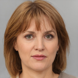 Joyful white adult female with medium  brown hair and grey eyes