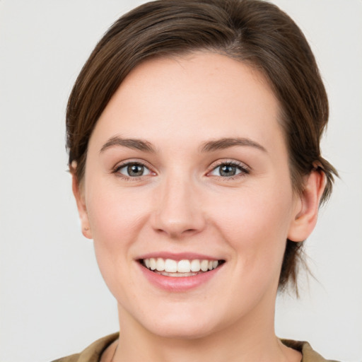 Joyful white young-adult female with medium  brown hair and green eyes