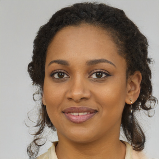 Joyful black young-adult female with long  brown hair and brown eyes