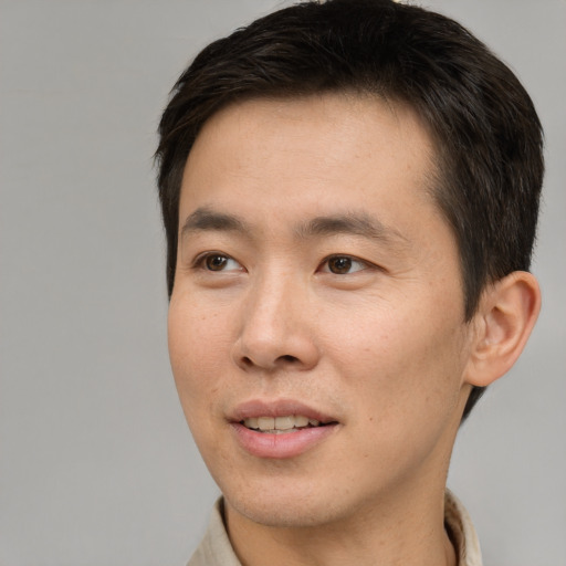 Joyful asian young-adult male with short  brown hair and brown eyes