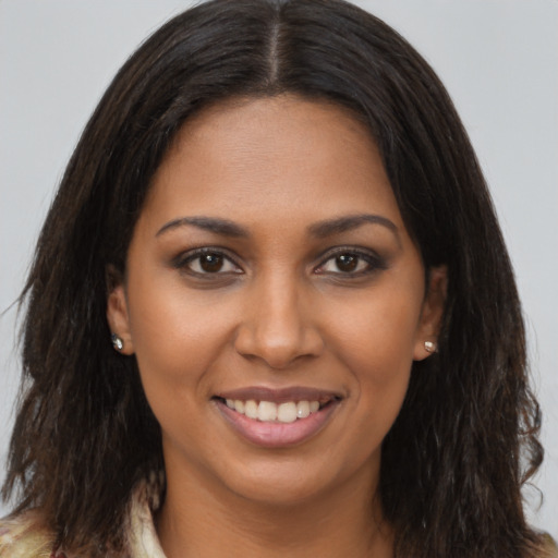 Joyful black young-adult female with long  brown hair and brown eyes