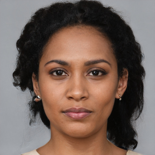 Joyful black young-adult female with medium  black hair and brown eyes