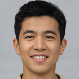 Joyful asian young-adult male with short  black hair and brown eyes